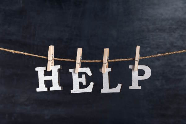 The letters "H", "E", "L" and "P" pegged to an overhead line